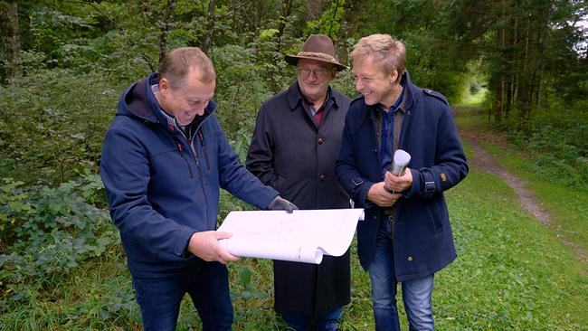 Max Müller im Gespräch mit Waldbesitzer Günter Kleinszig, der eine Karte studiert, und Historiker Wilhelm Wadl