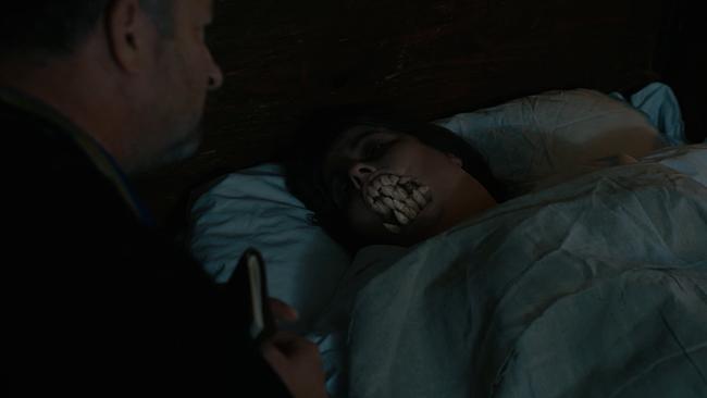 Die Moserin liegt im Bett, ein Priester an ihrer Seite. Ihr wachsen Zähne, damit kann sie die Beichte nicht mehr ablegen.