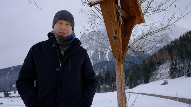 Max Müller steht neben dem Wachtkreuz