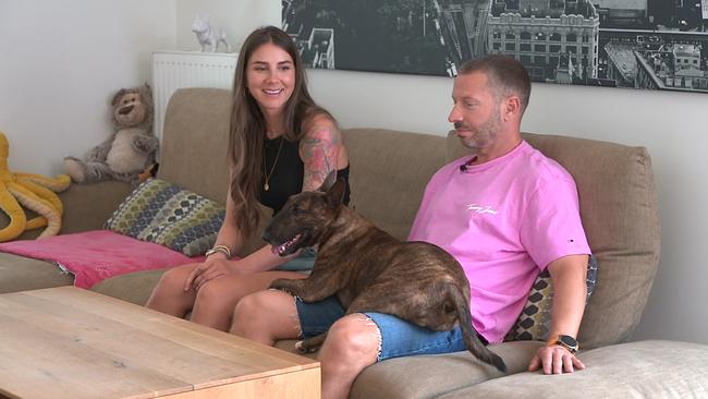 © ORF Ein junges Paar, Lucie und Jürgen Platzer sitzen auf einem Sofa, Hündin Phoebe sitzt auf dem Schoß von Jürgen Platzer