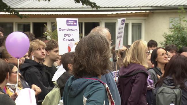 eine Gruppe junger Frauen und Männer halten Plakate mit der Schrift "Gemeinsam gegen Gewalt" in die Höhe, eine Frau hat einen Lila Luftballon