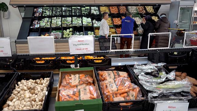 Mehrere Kundinnen und Kunden stehen im "Soogut" Sozialmarkt in St. Pölten an einer großen, gut gefüllten Gemüse- und Obstabteilung.