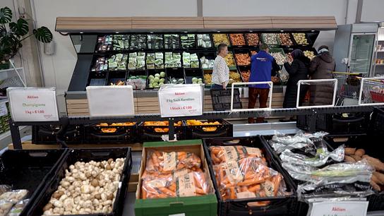 Mehrere Kundinnen und Kunden stehen im "Soogut" Sozialmarkt in St. Pölten an einer großen, gut gefüllten Gemüse- und Obstabteilung.