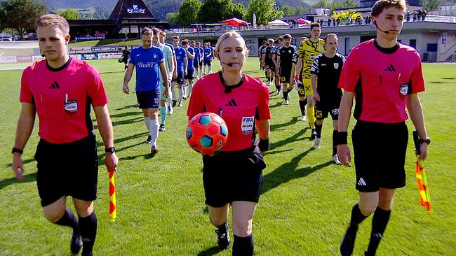 © ORF Schiedsrichterin Olivia Tschon betritt gemeinsam mit zwei Fußballmannschaften das Spielfeld vor Beginn eines Spiels.