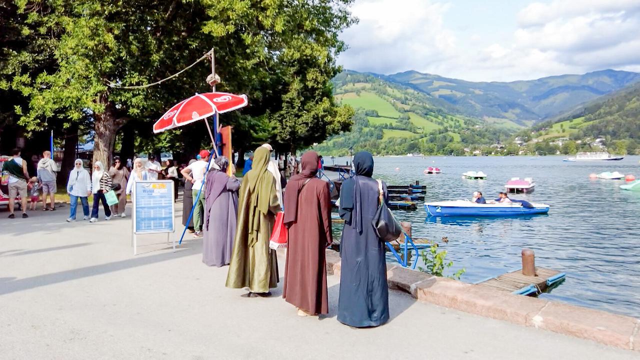 Arabische Gäste stehen am Ufer am Zeller See.