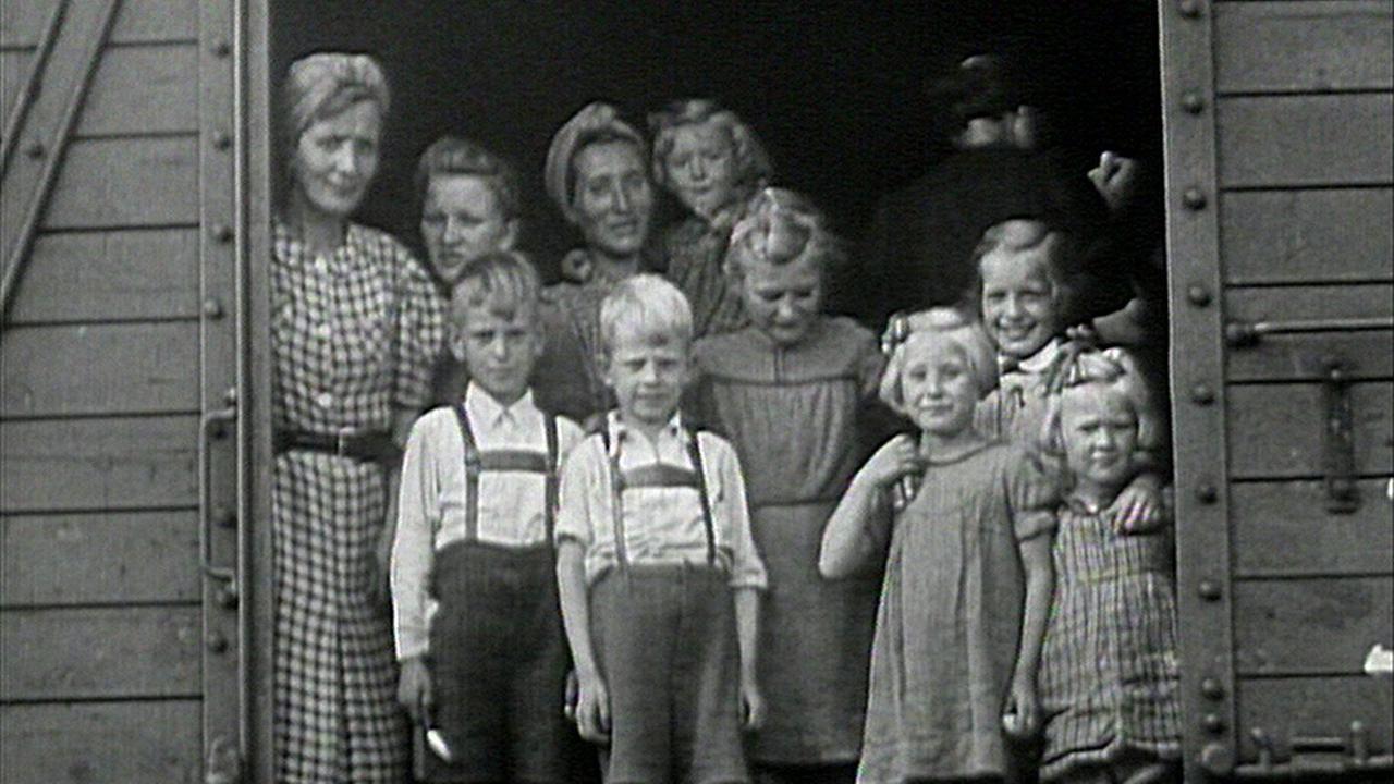 © ORF/Landesstudio Salzburg Historisches Foto "Die Kinder der Vertriebenen": Eine Gruppe aus Frauen und Kindern blickt aus der offenen Tür eines Güterwaggons.