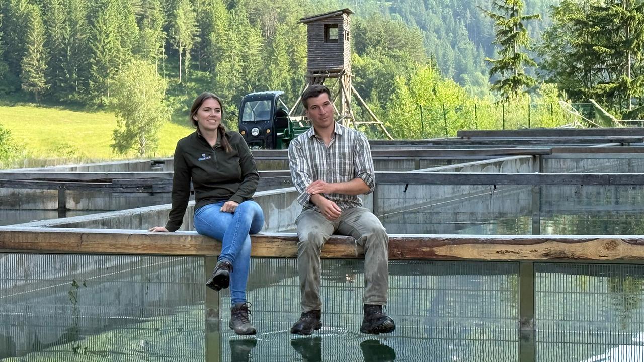 Die Fischbauern Marlene und Christian Kirchmayer, sitzend am Geländer ihrer Teiche