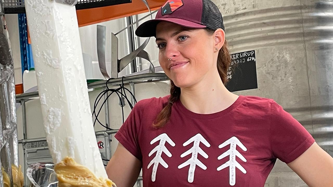 Kaugummiproduzentin Sandra Falkner steht lächeld an der Rührmaschine mit Kaugummimasse darauf