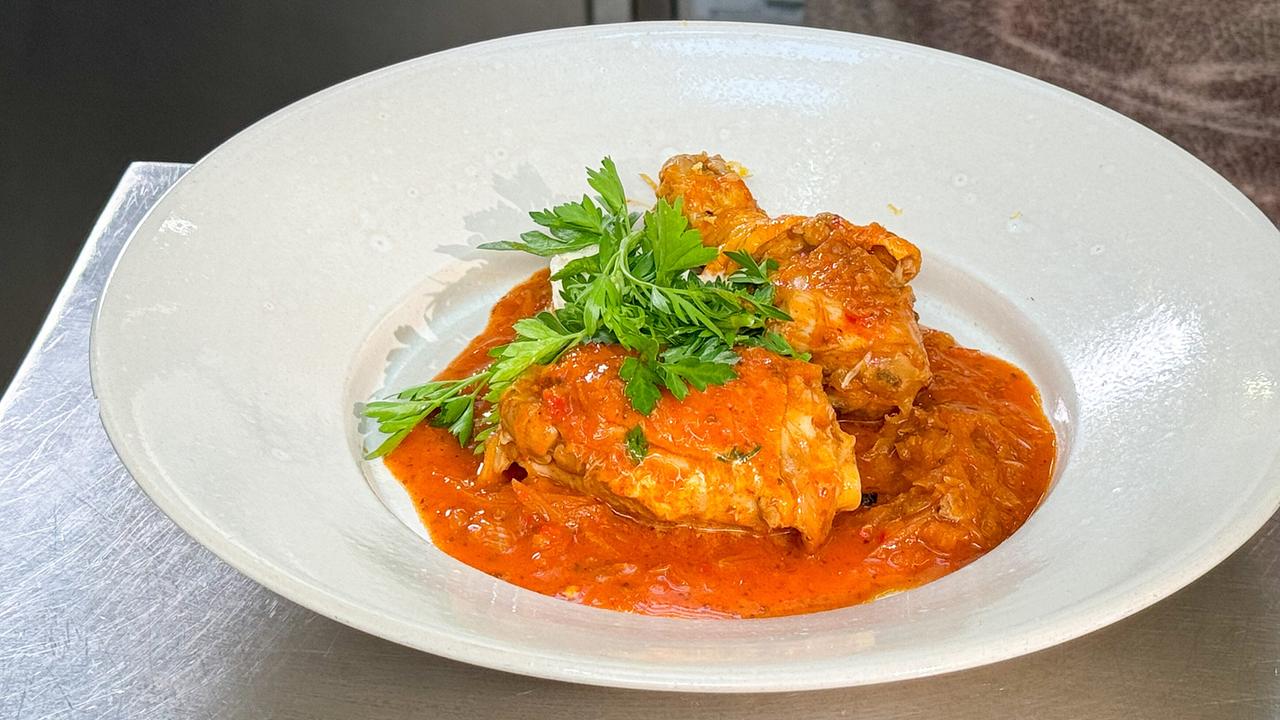 Krautfleisch mit Huhn auf einem weißen Teller, garniert mit frischer Petersilie. 