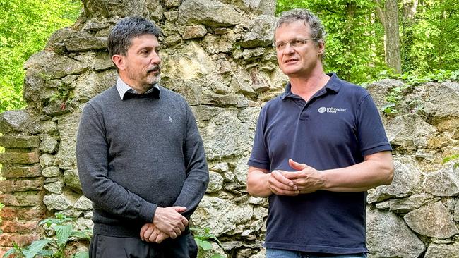 Die Archäologen Thomas Kühtreiber und Michael Doneus stehen vor einer Ruine. 