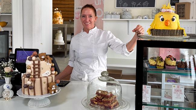 Konditorin Judith Walli hinter ihrer Theke mit zwei kunstvoll dekorierten Torten 
