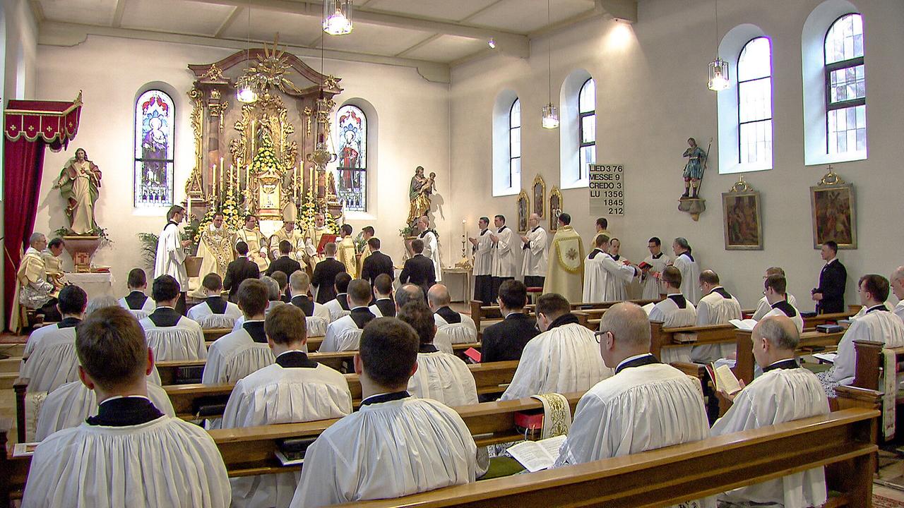 Niedere Weihen zu Maria Lichtmess im Priesterseminar der Priesterbruderschaft in Zaitzkofen in einer voll besetzten Kirche mit Geistlichen in liturgischen Gewändern vor einem reich geschmückten Altar.