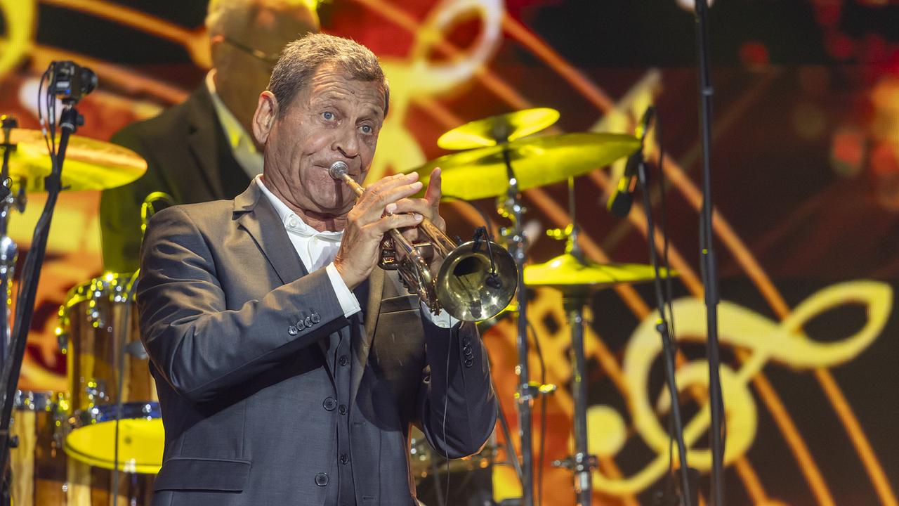 © ORF/Landesstudio Steiermark/Regine Schoettl Franz Posch spielt auf seiner Trompete mit den Dixielanders Hall auf einer bunt beleuchteten Bühne.