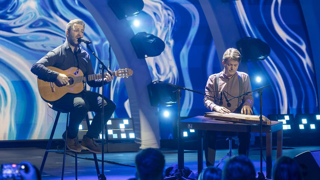© ORF/Landesstudio Steiermark/Regine Schoettl JOSH. an der Gitarre und Johannes Rohrer an der Zither musizieren im blauen Bühnenlicht.