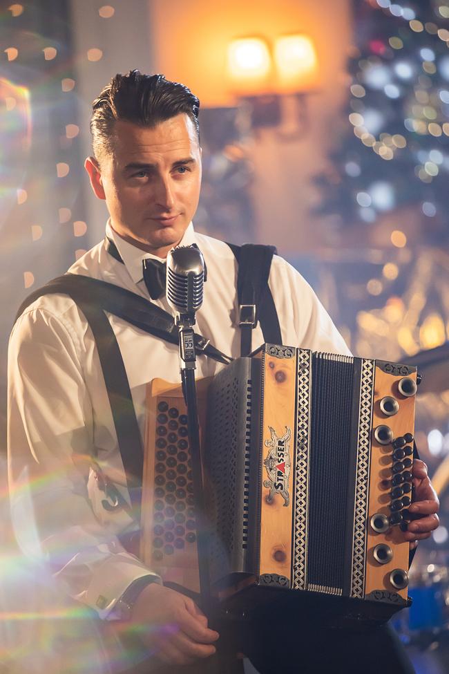 © ORF/Landesstudio Steiermark/Regine Schöttl Andreas Gabalier, elegant gekleidet, spielt in festlicher Atmosphäre eine Steirische Harmonika vor einem Retro‑Mikrofon.