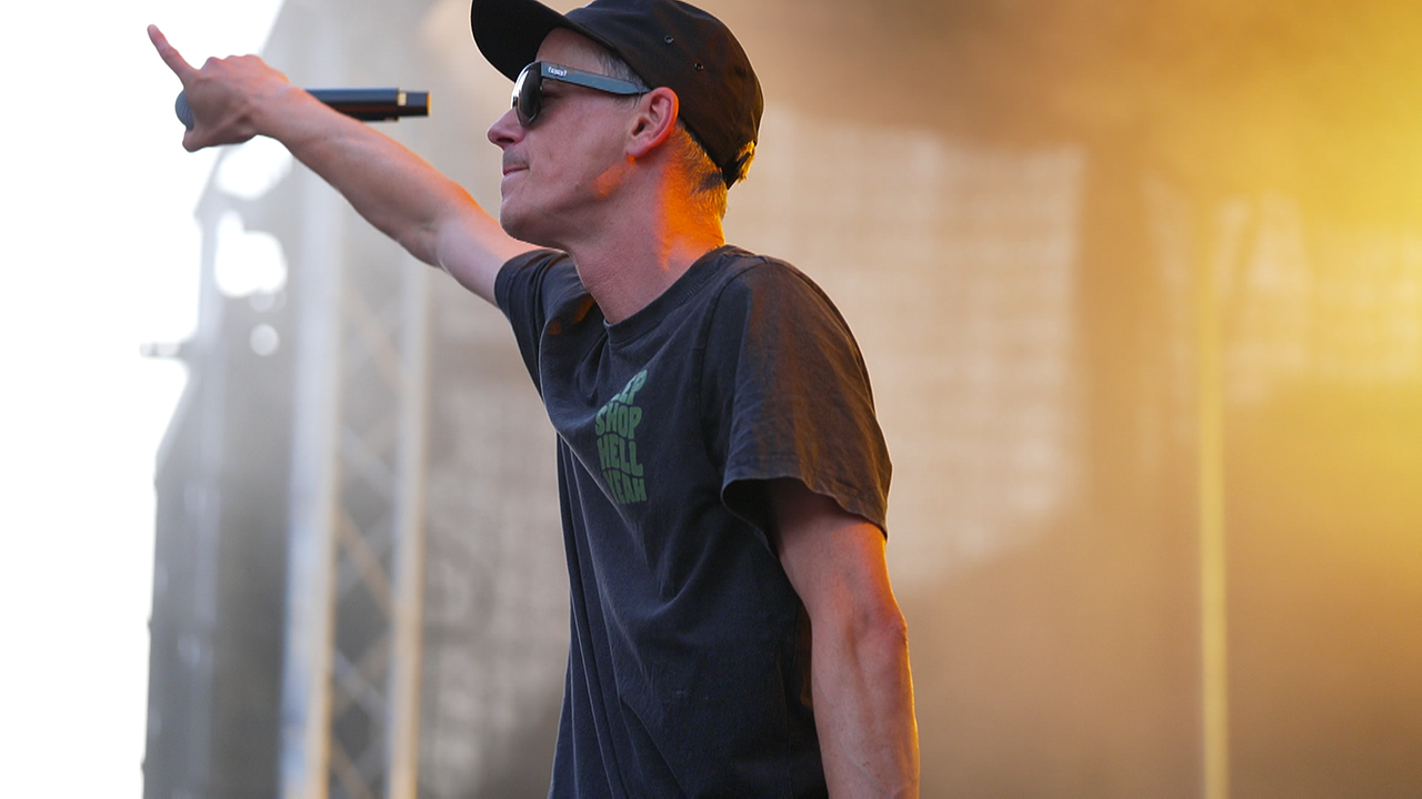 © ORF Tirol/Ferdinand Cibulka Rapper mit Mikrofon in der Hand auf einer Bühne während eines Auftritts.