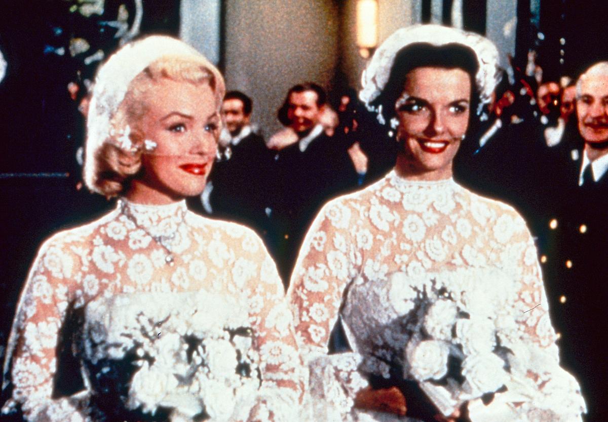 Marilyn Monroe als Lorelei Lee und Jane Russell als Dorothy stehen in weißen Hochzeitskleidern nebeneinander und lächeln glücklich