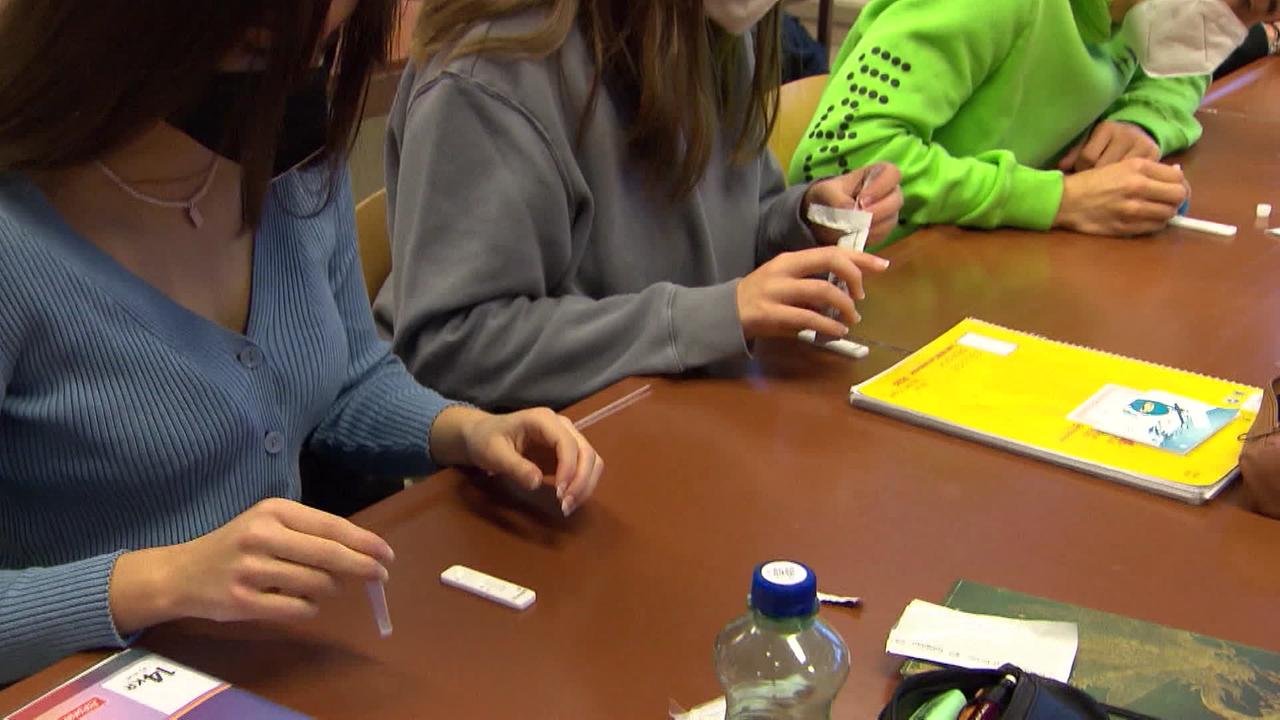 Schülerinnen und Schüler machen Corona-Tests im Klassenzimmer.