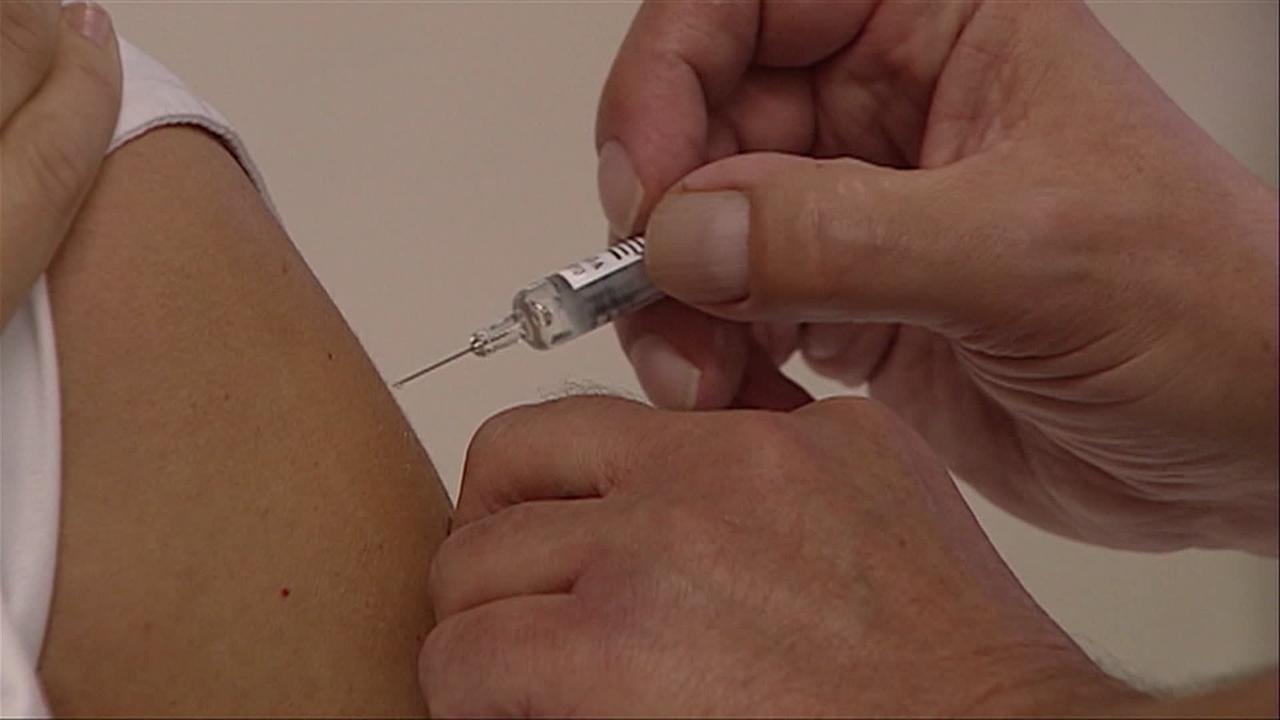 Eine Impfspritze wird gerade an einen Oberarm gesetzt.
