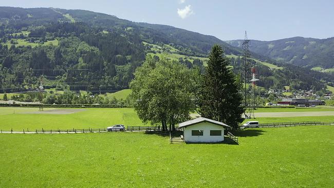 Inmitten von grünen Wiesen steht das Brunnenhaus der Gemeinde Stumm in Tirol.