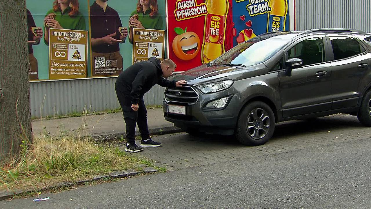 © ORF/ Lukas Grafleitner Herr A. betrachtet die Motorhaube von seinem Auto. Es steht vor einem Baum geparkt.