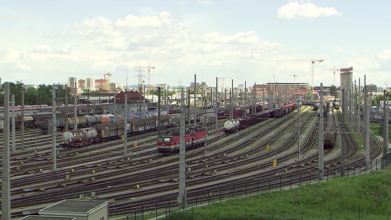 Am Bild sind die Gleise und Züge des Verschubbahnhofes in Graz zu sehen. Es sind rund 20 Gleise nebeneinander, teilweise mit Güterwaggons zu sehen.