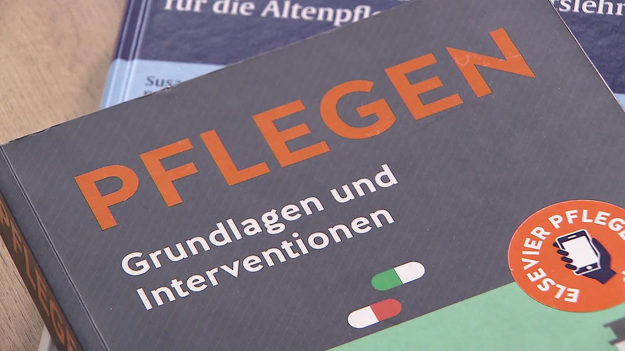 Am Bild sind Bücher für die Ausbildung von Pflegepersonal. Am obersten Buch steht: Pflegen - Grundlagen und Interventionen.