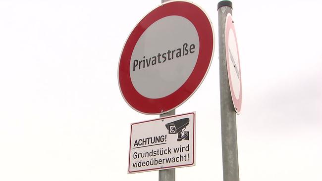 Am Bild ist ein "Durchfahrt verboten" Schild auf dem steht das Wort Privatstraße. Darunter ist ein Schild mit dem Bild einer Überwachungskamera und der Aufschrift: Achtung! Grundstück wird videoüberwacht.