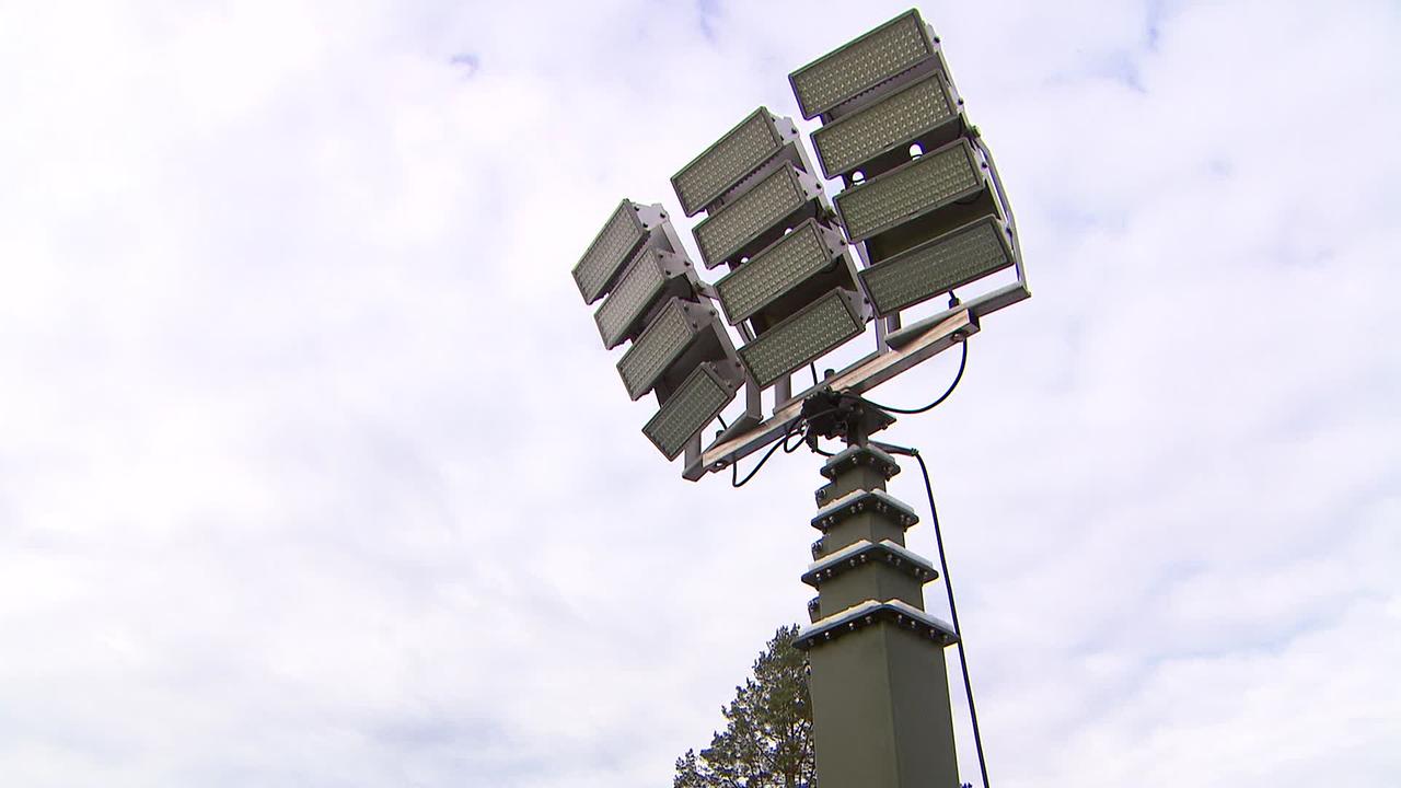 Am Bild ist eine große Flutlichtanlage für einen Fussballplatz zu sehen.