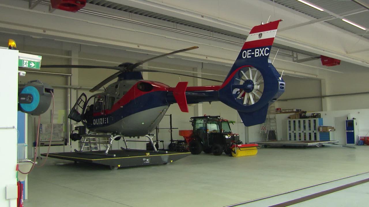 © ORF Am Bild ist ein Polizeihubschrauber in einem Hangar zu sehen. Er steht auf einer Plattform, die hinausgeschoben werden kann.