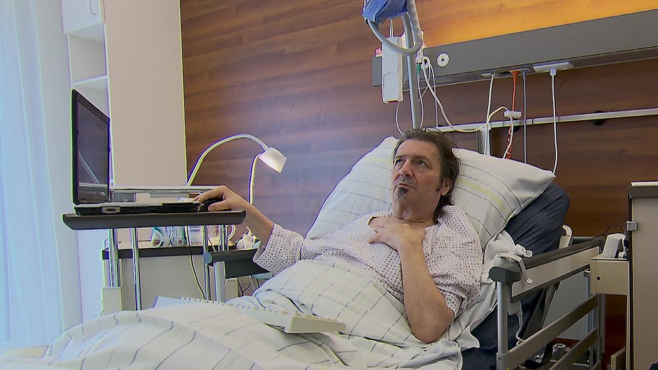 Herr W. ist ein 59-jähriger Mann. Er liegt in einem Spitalsbett. Neben dem Bett steht ein Tischchen mit einem Laptop den er erreichen kann.