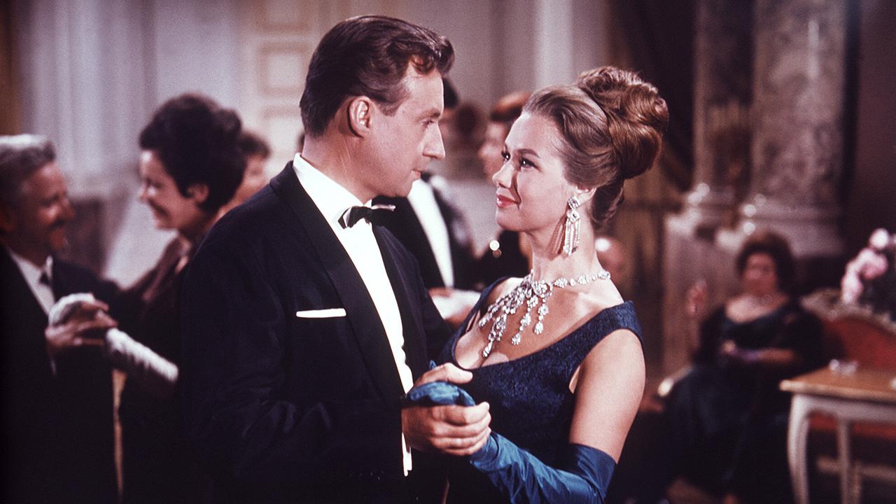 © ORF/Beta Film Peter Alexander als Otto Wilder in Abendanzug und Maria Sebaldt als Carlotta in nachtblauem Abendkleid sind bei einer gepflegten Veranstaltung beim Gesellschaftstanz