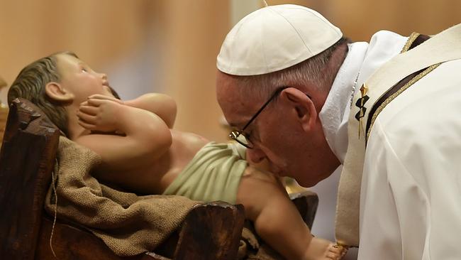 © ANDREAS SOLARO / AFP Katholische Christmette: Pope Francis kisses a figurine of baby Jesus as he celebrates a mass on Christmas eve marking the birth of Jesus Christ on December 24, 2016 at St Peter's basilica in the Vatican