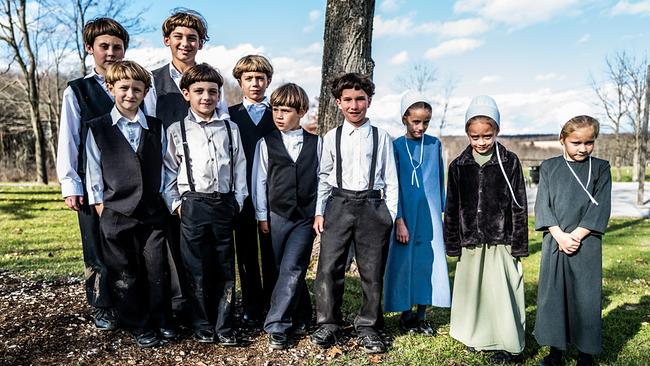 Das Leben der Amish: Eine Gruppe von Amish-Kindern stehen vor einem Baum