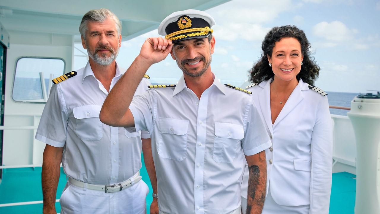 Gruppenfoto von Daniel Morgenroth als Staff-Kapitän, Florian Silbereisen als Kapitän und Barbara Wussow als Hoteldirektorin am Deck des Traumschiffes