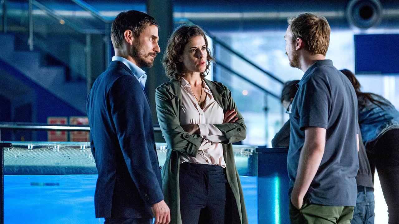 Xavi und Fina unterhalten sich mit Eduardo, hinter ihnen ist ein Wasserbassin mit Glaswänden und eine Stiege zu sehen