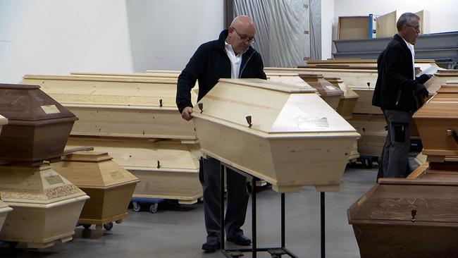 Partieführer Andreas Nowak  holt Särge für den Transport ab.