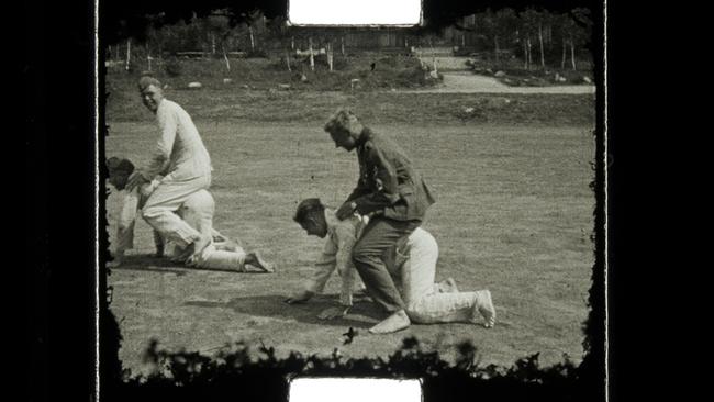 Männer auf Boden kauernd tragen andere Männer auf dem Rücken