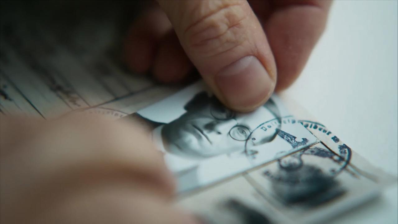 Nahaufnahme von Fingern, die einen antiquierten Pass fälschen