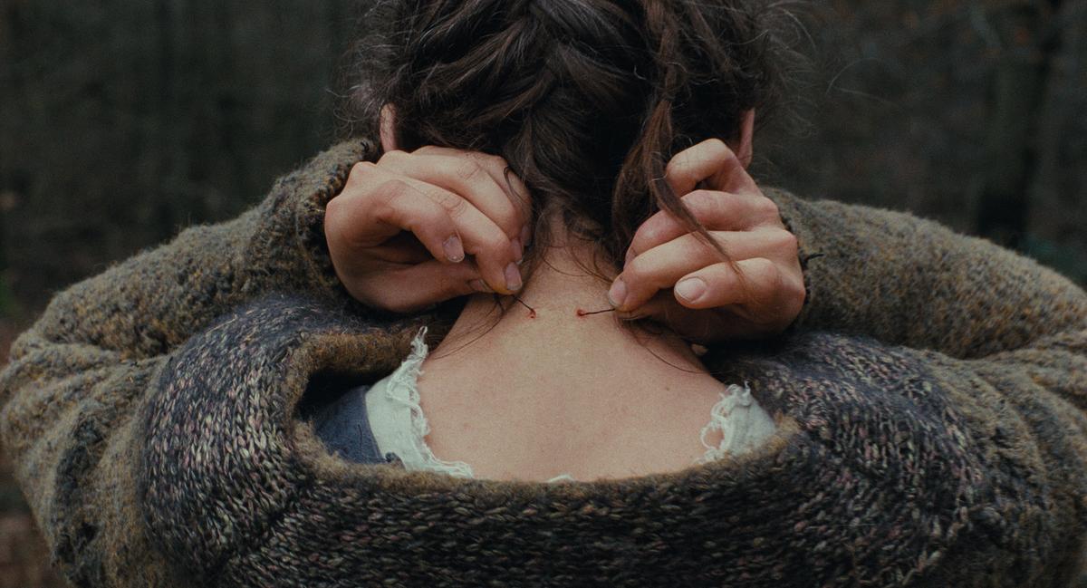 © ORF/Ulrich Seidl Film In einer Nahaufnahme sticht Agnes mit ihren Händen feine Nadeln in ihren Nacken.