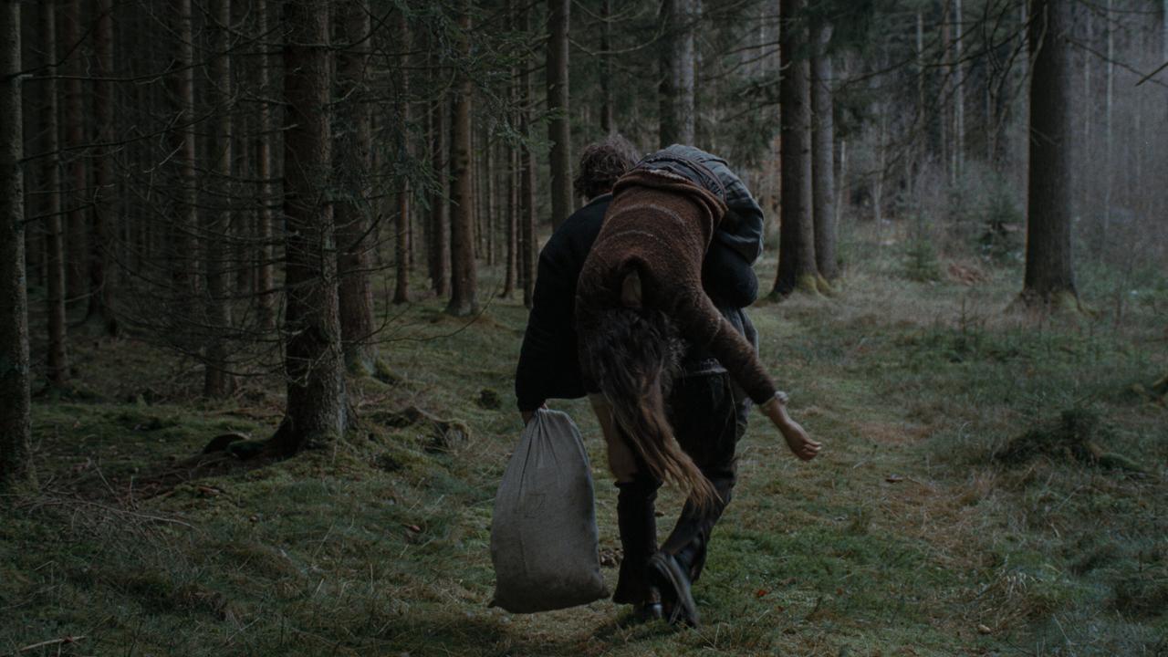 © ORF/Ulrich Seidl Film Wolf trägt Agnes, die über seiner Schulter hängt, durch einen stillen Wald.