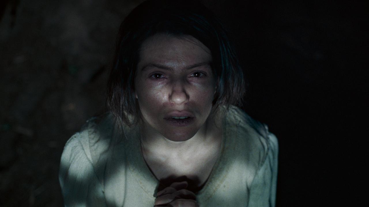 © ORF/Ulrich Seidl Film Agnes sitzt im Dunkeln mit gefalteten Händen, ein schmaler Lichtstrahl fällt auf ihr Gesicht.