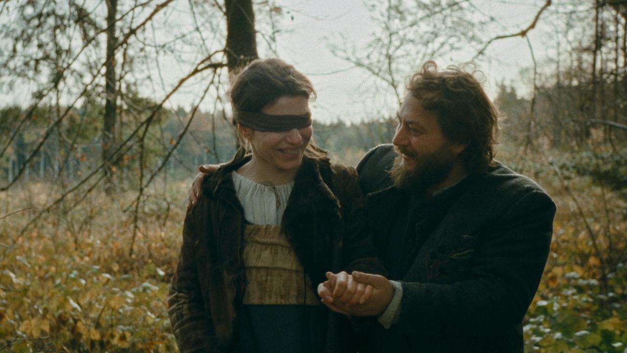 © ORF/Ulrich Seidl Film Agnes mit verbundenen Augen wird lächelnd von Wolf durch eine herbstliche Waldlandschaft geführt.