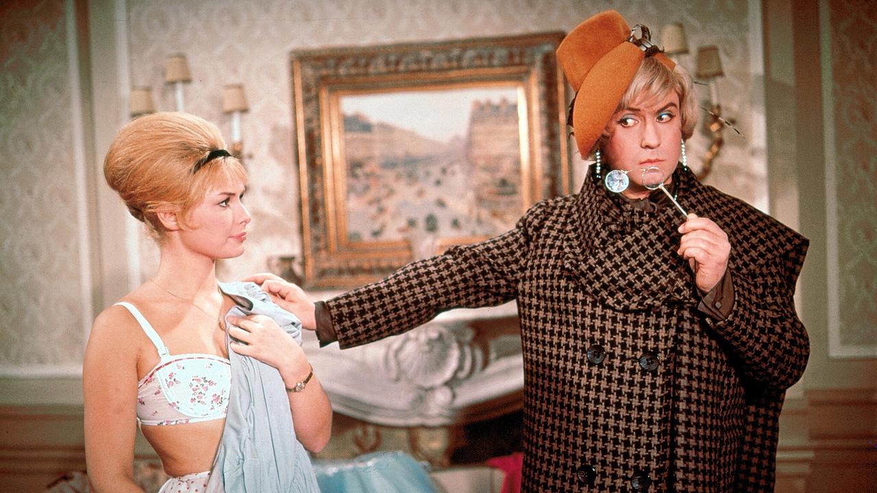 © ORF/Beta Film In einem Wohnzimer steht Vivi Bach in ihrer Unterwäsche, Peter Alexander in Frauenkleidern mit Mantel und Hut hält ihr ein Kleid hin