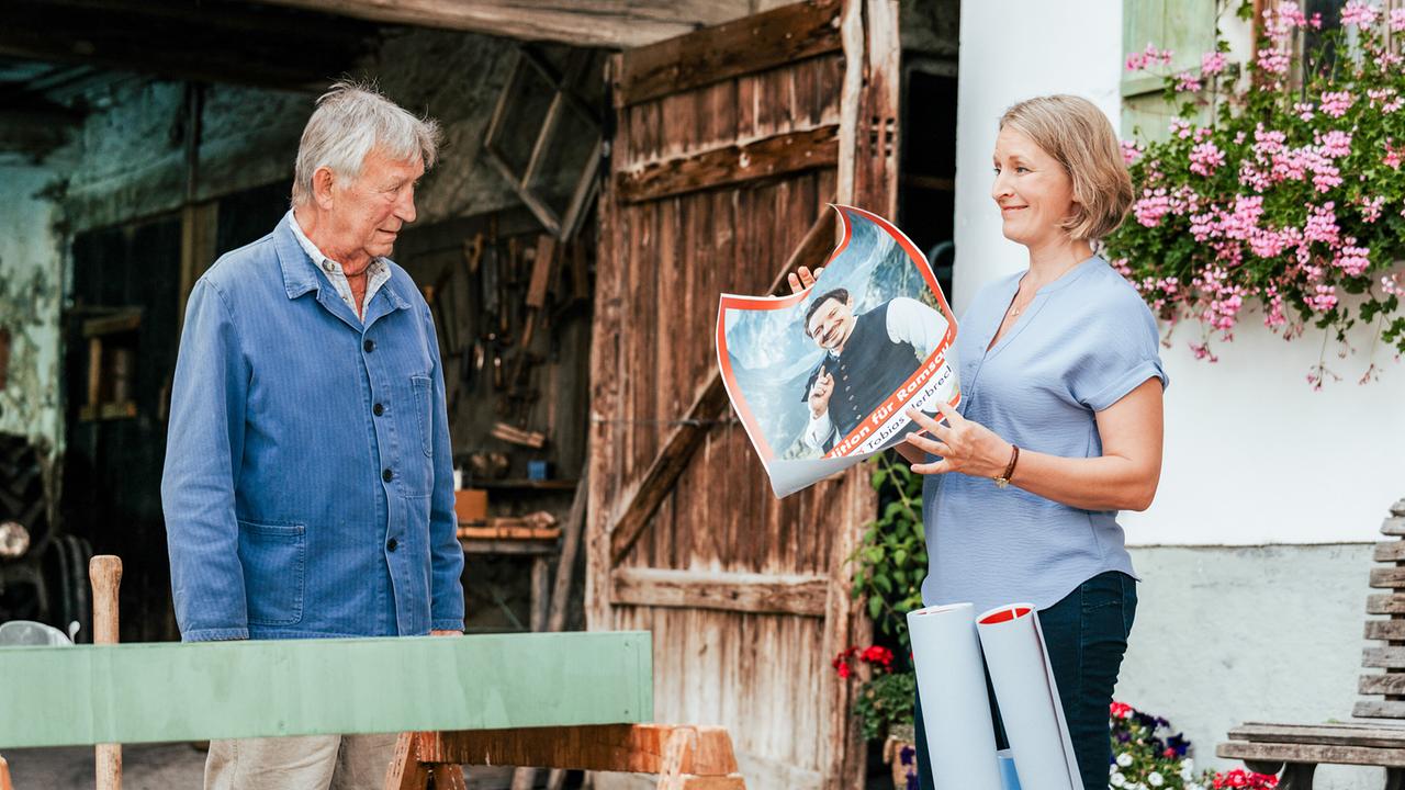 Emilie Hofer zeigt Franz Marthaler das Wahlplakat ihres Kontrahenten Tobias Herbrechter.