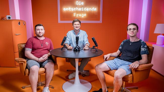 © ORF/Neulandfilm/Roland Klocker Dimitris Tyropolis, Konstantin Obermayr und Joost Herrebout sitzen an einem Tisch mit Mikros im "Die entscheidende Frage"-Studio