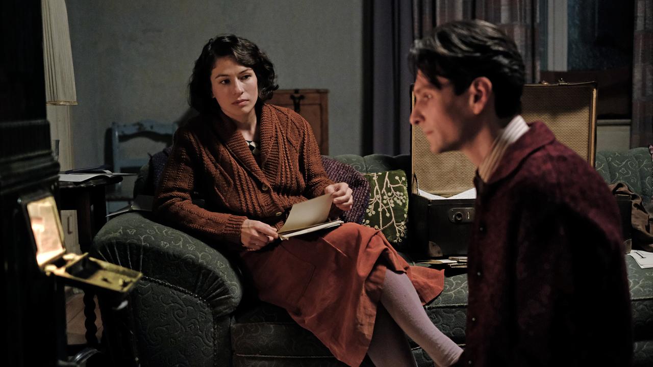 In einem Wohnzimmer sitzen sich Dora und Franz Kafka ernst gegenüber.