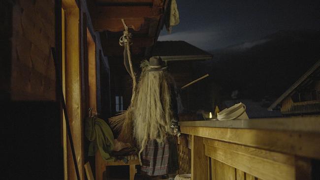 © ORF/Feature Filmproduktion/Fritz Kalteis Eine Perchte steht nachts auf dem Balkon eines Holzhauses.