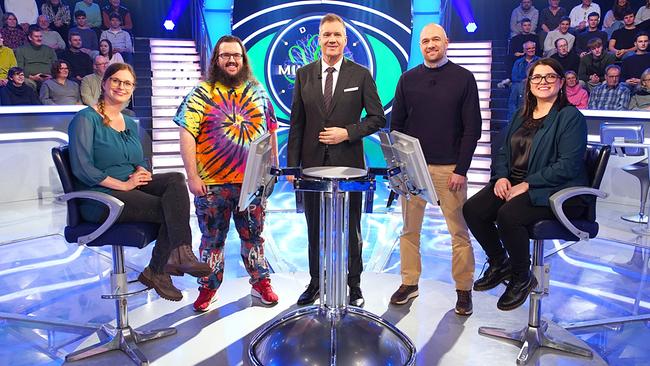 Ulrike Neumann, Stefan Reinisch, Armin Assinger, Christoph Friesinger und Madeleine Schwarz stehen um den Quizpult im "Millionenshow"-Studio, während das Publikum im Hintergrund zusieht.
