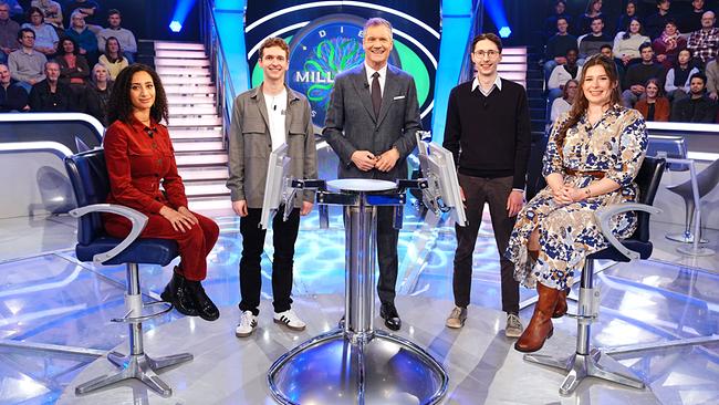 Mariam Rashwan, Niklas Sutter, Armin Assinger, Markus Klein und Leah Knas  stehen gemeinsam um den "Millionenshow"-Pult im TV-Studio mit Publikum im Hintergrund.